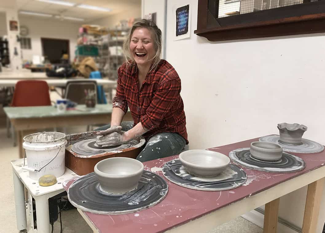 Pottery wheel class, student having fun.